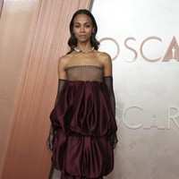 Sexy in gloves. Column dress merah anggur Yves Saint Laurent menjadi andalan Zoe Saldana. Sarung tangan berbahan jaring memberi sentuhan seksi. (Foto: Jordan Strauss/Invision/AP)