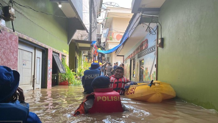 Brimob Polda Metro Jaya diturunkan mengevakuasi warga korban banjir di Kampung Melayu, Jaktim. (