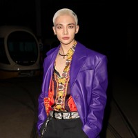 Saat tiba di peragaan busana Versace, Hyunjin Stray Kids memancarkan aura dark glamour dalam balutan kemeja bercorak khas Versace, celana hitam, dan coat berwarna ungu. Penampilannya semakin bold dengan belt dan boots bermotif kulit ular. Foto: dok. Instagram @versace