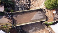 Hujan lebat yang mengguyur wilayah Cisarua, Kabupaten Bogor, Senin (3/3/2025) menyebabkan air sungai meluap. Dampaknya sebuah jembatan putus dan tidak bisa dilewati oleh warga. (ANTARA FOTO/Yulius Satria Wijaya)