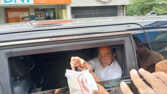 Presiden Ke-7, Joko Widodo (Jokowi) membagikan beras ke warga di Pasar Legi, Senin (3/3/2025).