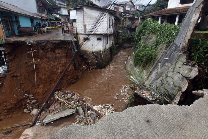 Jembatan dan jalan terputus akibat diterjang banjir bandang di Kampung Pensiunan, Desa Tugu Selatan, Cisarua, Kabupaten Bogor, Jawa Barat, Senin (3/3/2025). BPBD Kabupaten Bogor, Jawa Barat mencatat sebanyak 423 jiwa di Kampung Pensiunan tersebut terdampak bencana banjir akibat luapan Sungai Ciliwung. ANTARA FOTO/Yulius Satria Wijaya/Spt.