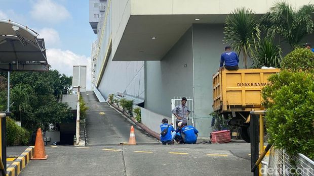 Lalu lintas di Jalan Margonda Raya arah Jakarta tersendat karena air yang menggenangi jalan. Luapan kali melewati bangunan bengkel bak air terjun. (Devi P/detikcom)