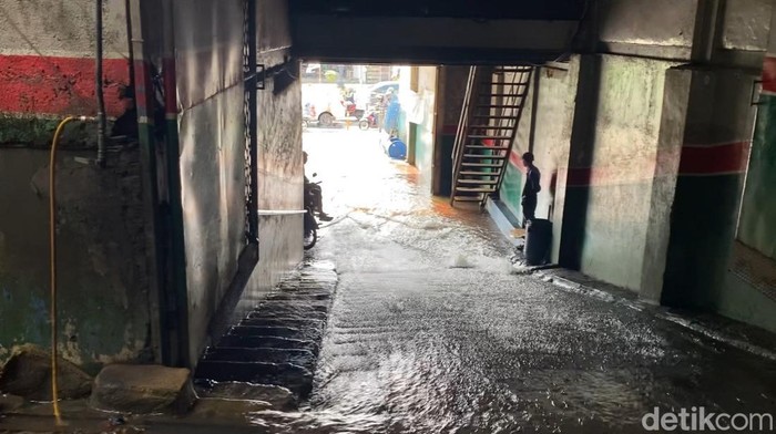 Lalu lintas di Jalan Margonda Raya, Depok arah Jakarta tersendat karena genangan air. Banjir muncul dari luapan sungai yang mengalir lewat bangunan bengkel. (Devi Puspitasari/detikcom)