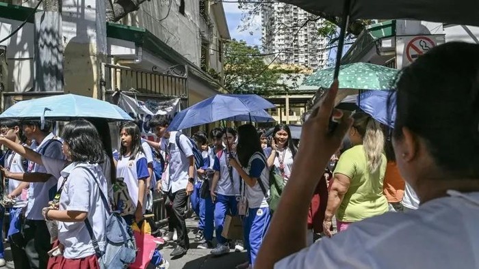 Students leave the school in Manila on March 3, 2025, where classes are suspended due to extreme heat. (AFP)