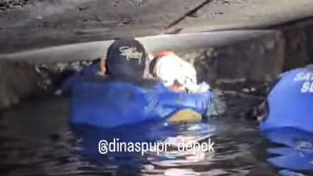 Petugas Dinas PUPR Depok membersihkan sampah sisa banjir di gorong-gorong Jalan Margonda Raya, Depok, Jawa Barat. Mereka sampai menyelam ke gorong-gorong. (dok PUPR Depok)