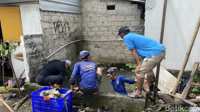 Petugas membersihkan sampah sisa banjir di Jalan Margonda Raya, Depok, Jawa Barat arah Jakarta Selatan. (Devi/detikcom),