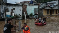 Warga tampak menggunakan pelampung untuk pergi ke daerah yang lebih tinggi.  
