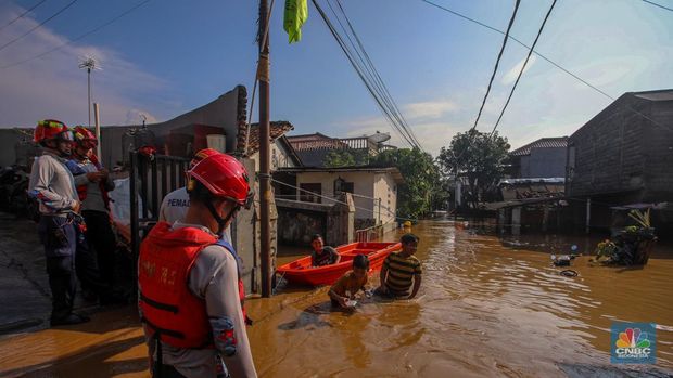 Warga beraktivitas saat banjir melanda kawasan Pejaten Timur, Pasar Minggu di Jakarta, Senin (3/3/2025). (CNBC Indonesia/Faisal Rahman)