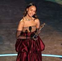 Saat naik ke atas panggung untuk menerima piala Oscars pertamanya, Zoe Saldana mencuri atensi dengan penampilannya yang glamor. Zoe mengenakan gaun yang dibuat khusus untuknya dari rumah mode Saint Laurent. Foto: Getty Images/Kevin Winter