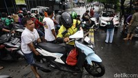 Sejumlah pengendara menggotong kendaraan roda dua melintasi median jalan untuk menghindari banjir yang merendam jalan Raden Fatah, Ciledug, Kota Tangerang, Banten, Selasa (4/2/2025).