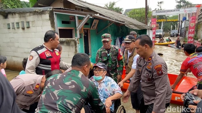 Banjir merendam Perumahan Asri Sawangan, Depok hingga ketinggian mencapai 1,5 meter. TNI-Polri mengevakuasi warga korban banjir yang hendak mau cuci darah. (Devi P/detikcom)