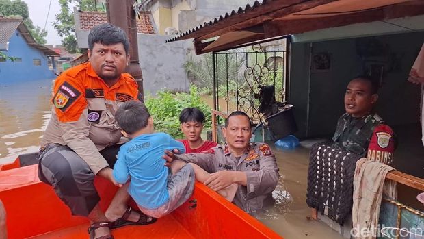 Banjir merendam Perumahan Asri Sawangan, Depok hingga ketinggian mencapai 1,5 meter. TNI-Polri mengevakuasi warga korban banjir yang hendak mau cuci darah. (Devi P/detikcom)