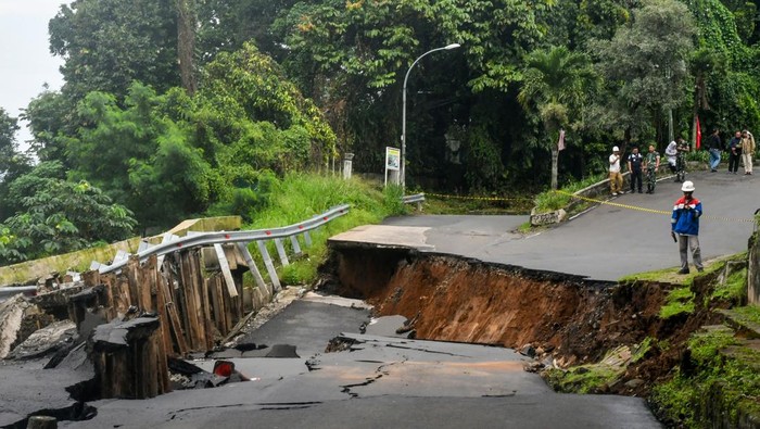 Jalan ambles menuju Stasiun Batu Tulis Kota Bogor Warga merekam video lokasi jalan yang ambles di jalan Saleh Danasasmita, Kota Bogor, Jawa Barat, Selasa (4/3/2025). Hujan deras dengan intensitas tinggi di wilayah Bogor pada Selasa (4/3/2025) dini hari mengakibatkan jalan utama menuju Stasiun Batu Tulis, Kota Bogor tersebut ambles sepanjang 50 meter dan arus lalu lintas ditutup total untuk sementara waktu. ANTARA FOTO/Arif Firmansyah/agr