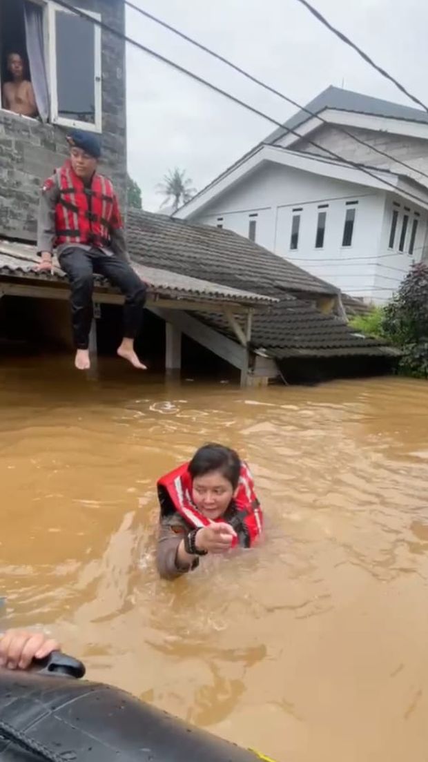 Kapolsek Pesanggrahan AKP Seala Syah Alam berenang membantu evakuasi warga yang terjebak banjir di Kompleks IKPN Bintaro, Pesanggrahan, pada Selasa (4/3/2025).