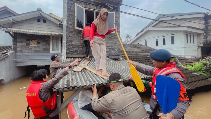 Kapolsek Pesanggrahan AKP Seala Syah Alam (paling kiri) terjun membantu evakuasi warga yang terjebak banjir.