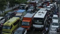 Mobil dan motor terjebak macet akibat masih adanya genangan air di jalan tersebut.