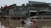 Ketinggian banjir tampak menutupi atap rumah satu lantai.