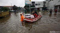 Warga keluar masuk pasar menggunakan perahu karet.