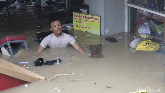 Pedagang menyelamatkan barang dagangan saat terjadi banjir di Mega Mall, Bekasi, Jawa Barat, Selasa (4/3/2025).