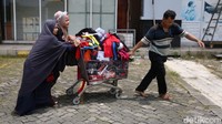 Pedagang berusaha menyelamatkan barang dagangan yang masih bisa diselematkan dengan menggunakan troli ke tempat kering dan aman.