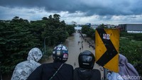 Warga yang melintas di fly over K.H Noer Alie pun menghentikan lajunya untuk menonton perjuangan warga untuk pulang.