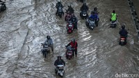 Sejumlah pengendara motor nekat melawan arus air yang membanjiri jalan Jenderal Sudirman, Kota Bekasi.