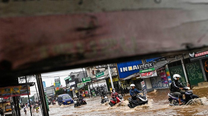 Potret Banjir Merendam Kawasan Sawangan Depok Petugas membantu warga berputar arah untuk menghindari banjir di Sawangan, Depok, Jawa Barat, Selasa (4/3/2025). Hujan deras sejak Senin malam - Selasa dini hari (3-4 Maret) membuat sejumlah sungai di wilayah Depok meluap hingga berakibat banjir di sejumlah permukiman dan jalan raya di kawasan tersebut. ANTARA FOTO/Sigid Kurniawan/agr