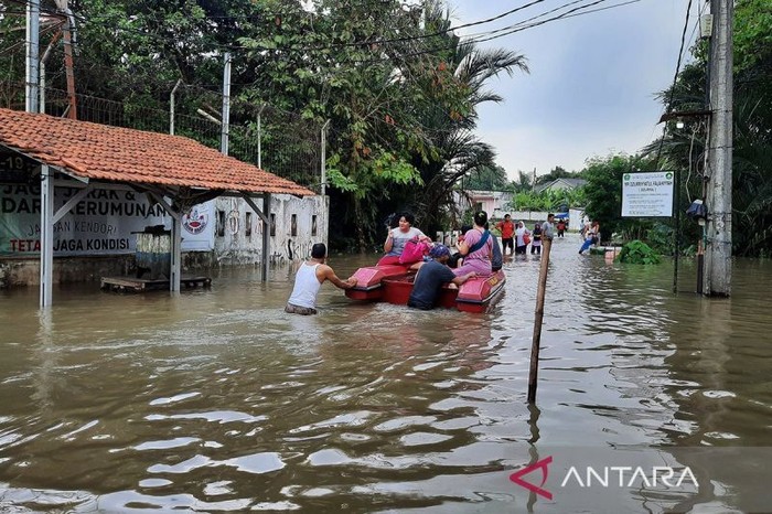 Sejumlah warga melintas genangan air menggunakan perahu karet saat hendak mengungsi ke tempat aman di Kabupaten Tangerang, Rabu (29/1/2025). (Azmi Samsul Maarif/am/ANTARA)