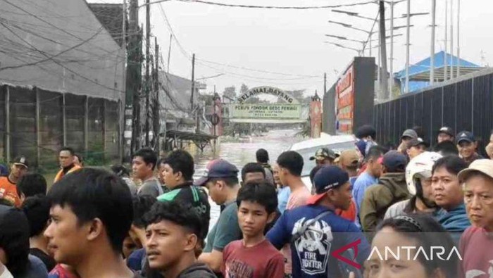 Sejumlah warga menyaksikan proses evakuasi korban banjir dari titik aman akses menuju Perumahan Pondok Gede Permai Kecamatan Jartiasih, Kota Bekasi, Jawa Barat, Selasa. (ANTARA/Pradita Kurniawan Syah)