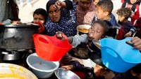 Mereka berebut makanan sambil memegang panci kosong di depan dapur umum.