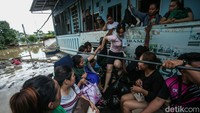 Satu per satu warga yang terjebak banjir dievakuasi menggunakan perahu karet.