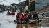Tim SAR gabungan melintasi banjir yang tingginya mencapai atap rumah.