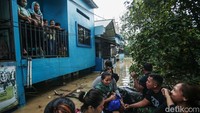 Sejumlah warga menunggu dievakuasi dari lantai dua rumah.