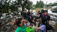Tim SAR wara-wiri menggunakan perahu karet untuk mengevakuasi warga.