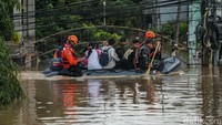 Perahu karet yang dikerahkan untuk mengevakuasi warga menyusuri jalanan yang terendam banjir.