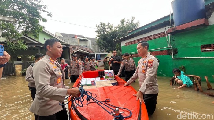 TNI dan Polri membagikan makanan ke warga yang terdampak banjir di Sawangan, Depok. (Devi/detiikcom).