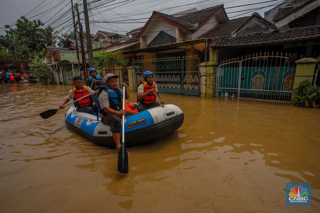 Warga melintasi banjir yang melanda Perumahan Villa Nusa Indah 1, Kecamatan Gunung Putri, Kabupaten Bogor, Jawa Barat, Selasa (4/3/2025). (CNBC Indonesia/Faisal Rahman)