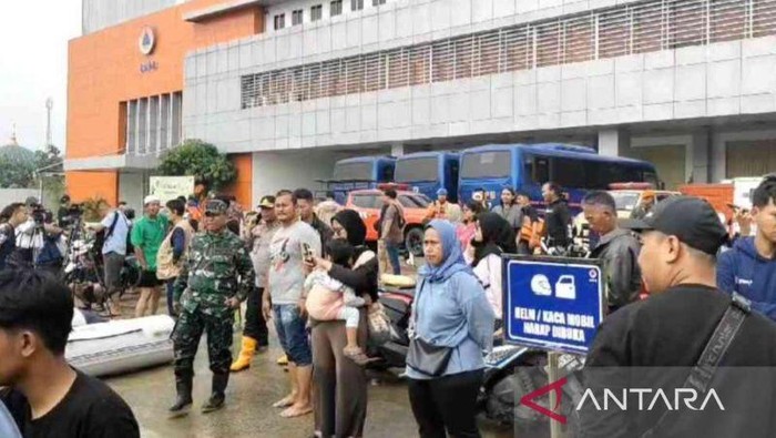 Warga menyaksikan proses evakuasi korban banjir dari titik depan gedung BPNB di Kecamatan Jatiasih, Kota Bekasi, Jawa Barat, Selasa. (ANTARA/Pradita Kurniawan Syah).