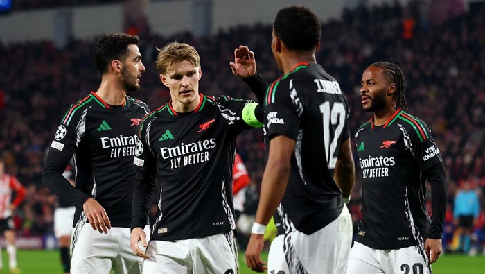 Soccer Football - Champions League - Round of 16 - First Leg - PSV Eindhoven v Arsenal - Philips Stadion, Eindhoven, Netherlands - March 4, 2025  Arsenals Martin Odegaard celebrates scoring their sixth goal with Arsenals Jurrien Timber, Arsenals Mikel Merino and Arsenals Raheem Sterling Action Images via Reuters/Matthew Childs