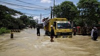 Sejumlah kendaraan nekat menerobos banjir yang merendam Jalan Gabus Raya.