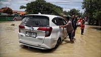 Tak semua kendaraan bisa menerobos banjir di jalan tersebut. Ada juga mobil yang mogok setelah menerobos banjir.