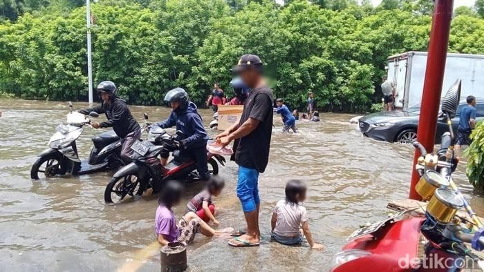 Bapak temani anak main banjir di Jakbar