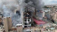 Tampak api berkobar pada lantai atas gedung yang difungsikan sebagai gudang tersebut. 