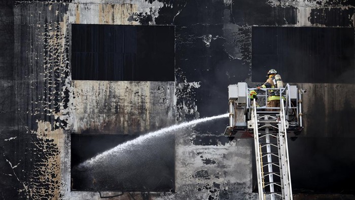 Gudang di Lima Peru Terbakar, Asap Mengepul Firefighters on a telescopic ladder work to extinguish a massive fire in a clandestine warehouse in downtown Lima, Peru, March 4, 2025. REUTERS/Sebastian Castaneda