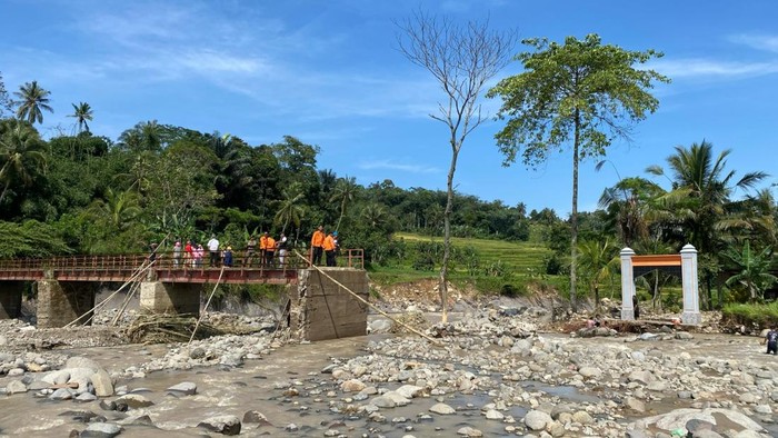 Hujan deras membuat Sungai Cipamingkis meluap hingga memutus akses jalan. Akibatnya, ada satu kampung terisolasi karena akses putus. (Dok BPBD Kab Bogor)