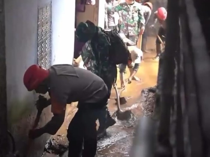 Jajaran Polres Bogor bersama TNI membersihkan lumpur sisa banjir di Cisarua, Bogor.
