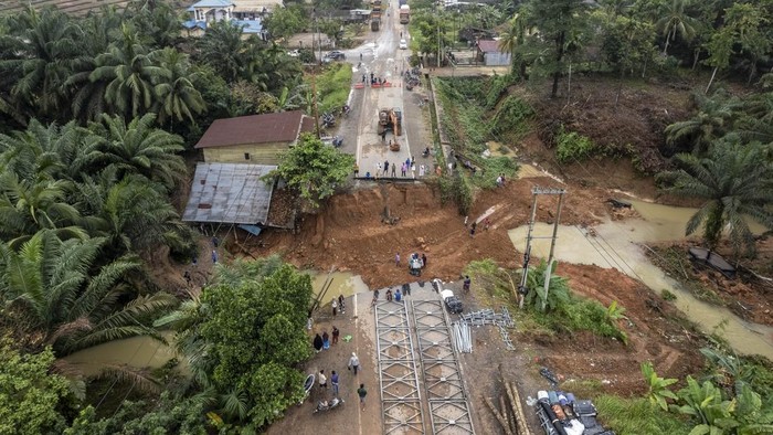 Jalan amblas di Bungo belum bisa dilintasi Foto udara warga menyaksikan kondisi jalan lintas Sumatera yang amblas di Desa Sirih Sekapur, Bungo, Jambi, Rabu (5/3/2025). Jalan nasional yang menghubungkan Provinsi Jambi dengan Sumatera Barat yang amblas pada Minggu (2/3) akibat hujan deras itu hingga Rabu (5/3) pagi masih belum bisa dilintasi, sementara Balai Pelaksana Jalan Nasional (BPJN) Jambi masih berupaya membangun jembatan darurat. ANTARA FOTO/Wahdi Septiawan/nym.