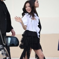 Personel Blackpink ini mengenakan atasan korset putih dengan detail ritsleting, dipadukan dengan kemeja berlengan puff dan rok mini tulle yang dilapisi renda bunga. Foto: Getty Images/Arnold Jerocki