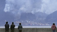 Warga menyaksikan kebakaran hutan di kota Ofunato, prefektur Iwate, Jepang utara, Selasa (4/3/2025).  